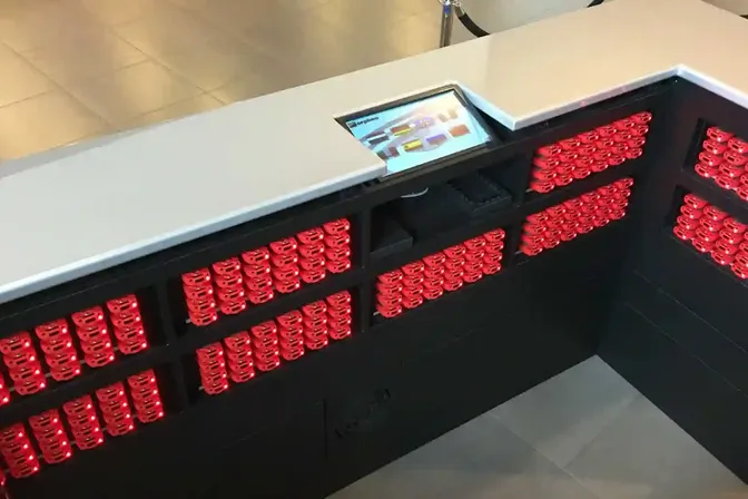 Uitgiftebalie met audioguides in laadrekken bij CORPUS