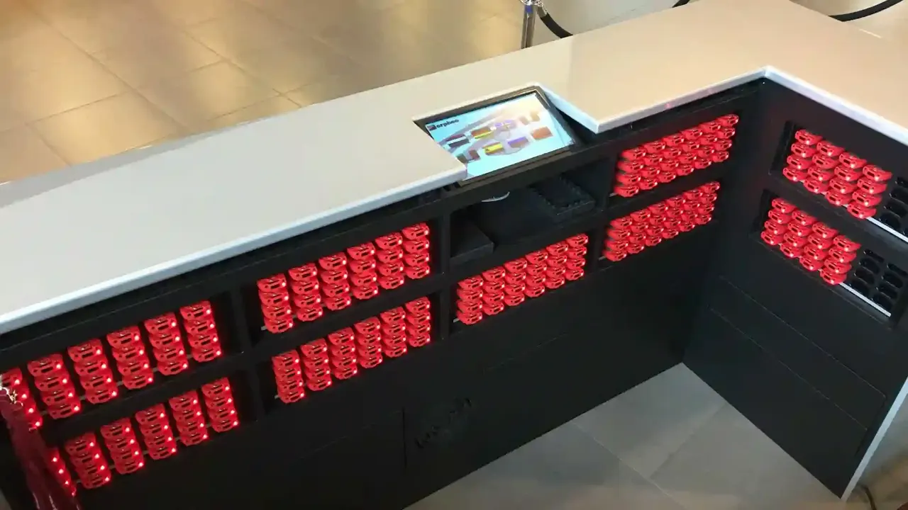 Uitgiftebalie met audioguides in laadrekken bij CORPUS