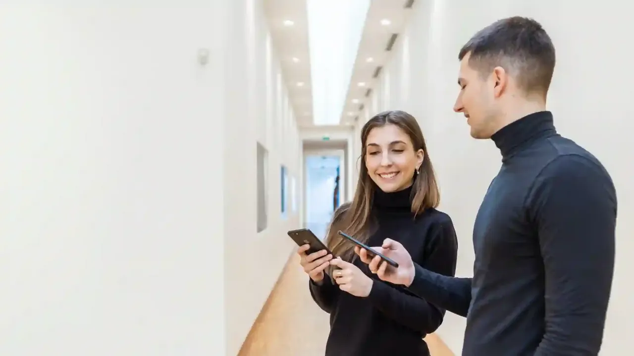 Twee bezoekers gebruiken een museumapp op hun smartphone