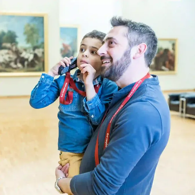 Vader en zoon met een Orpheo Mikro audioguide in een museum