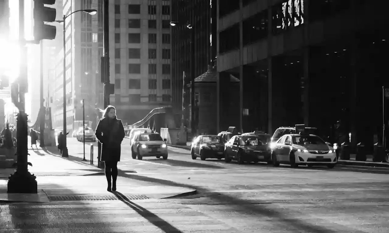 Iemand loopt alleen door een zonnige straat in de stad