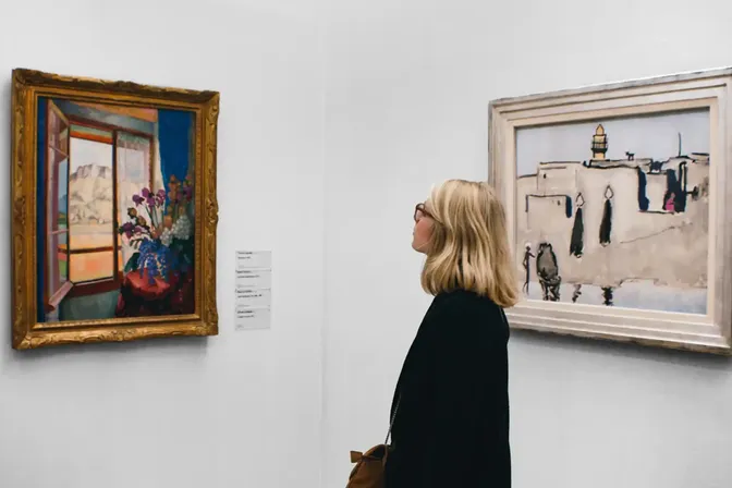 Bezoekster bekijkt schilderijen in een museumzaal