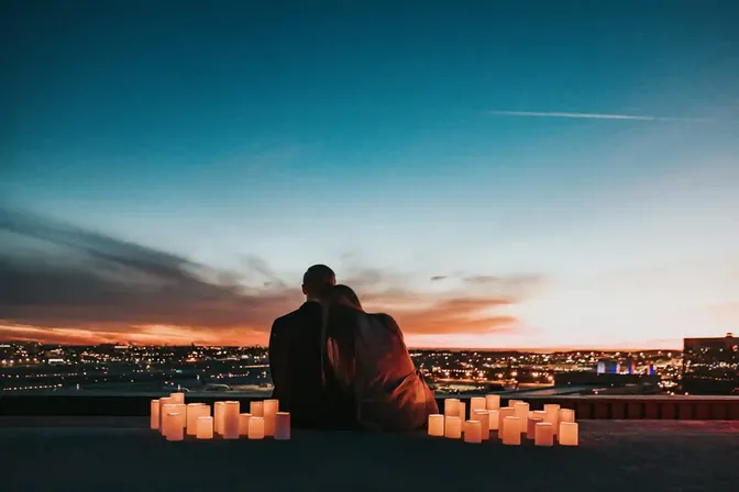 Stel kijkt bij zonsondergang uit over een stad